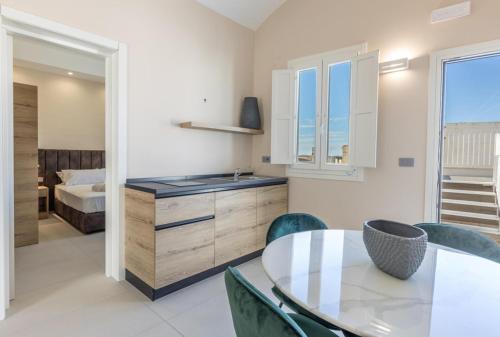 a kitchen with a table and chairs and a bedroom at Relais Ena in Gallipoli