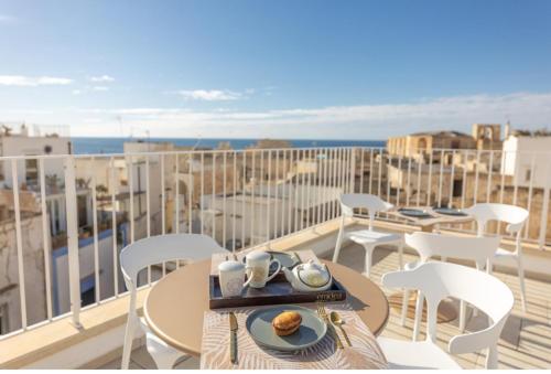 a table and chairs on a balcony with a view of the ocean at Relais Ena in Gallipoli