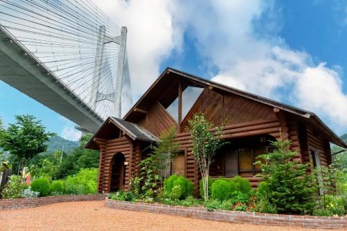 a wooden house with a bridge in the background at Chichibu Park Bridge Camp Base - Vacation STAY 12868v in Chichibu