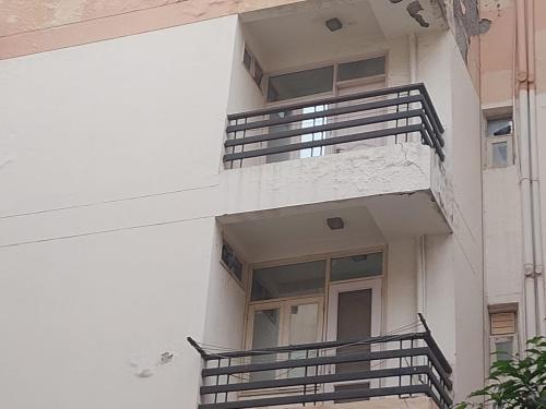 an external view of a white building with balconies at Mavi stays in Chhatikara