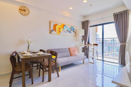 una sala de estar con una mesa y un sofá en Nice Condo - Soho Building, en Ho Chi Minh
