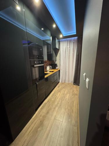 a kitchen with black cabinets and a blue ceiling at MERLIN Apartments in Zamość