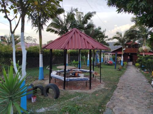 a gazebo in a yard with palm trees at Cabaña Campestre San Fernando in Albán