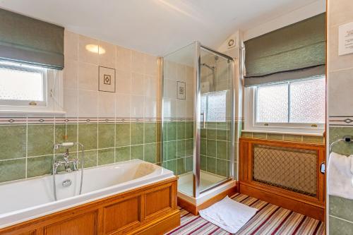 a bathroom with a bath tub and a shower at Banbury Cross B&B in Banbury