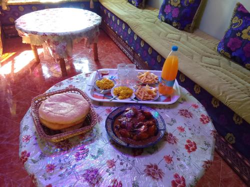 una mesa con una bandeja de comida en un sofá en Auberge l'Etoile de ketama, en Tlata Ketama