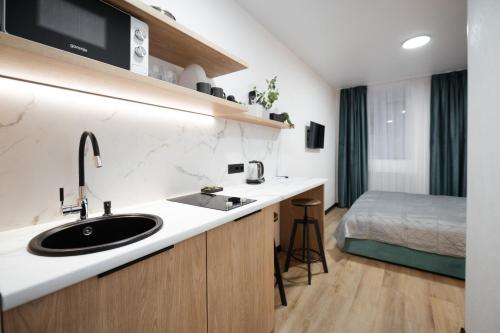 Un baño con lavabo y una cama en una habitación. en Апартаменти MYFREEDOM поруч Софіївська площа, Майдан Незалежності, en Kiev