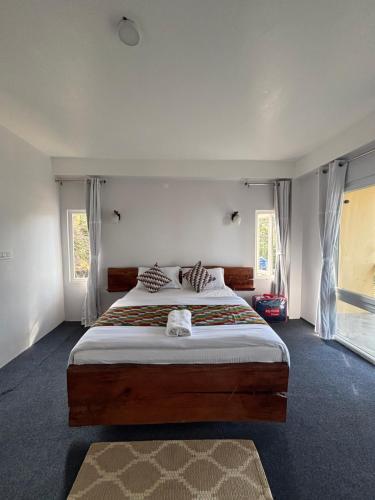 a bedroom with a large bed and two windows at Vanam Vihara in Takdāh