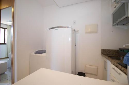 a kitchen with a white refrigerator in a room at OZPED Flats Particulares Edifício Life Resort in Brasilia