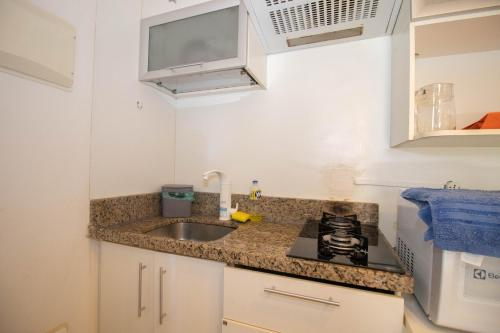 a small kitchen with a sink and a stove at OZPED Flats Particulares Edifício Life Resort in Brasilia