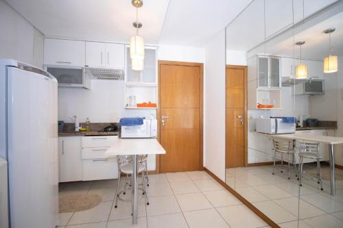a kitchen with white cabinets and a white refrigerator at OZPED Flats Particulares Edifício Life Resort in Brasilia