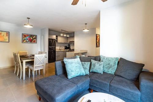 a living room with a blue couch and a kitchen at New apartment ready for FUN Cabo dream in Cabo San Lucas