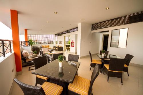 a dining room and living room with a table and chairs at El Principe Hoteles in Piura