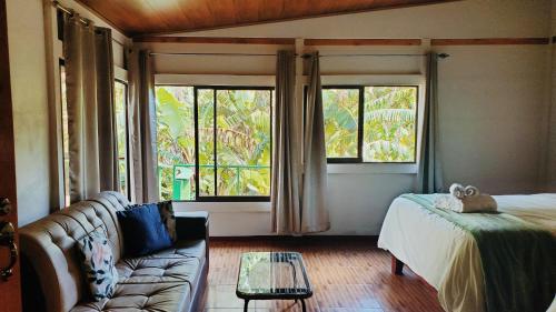 a living room with a couch and a large window at Grand Luna - Monteverde in Tilarán