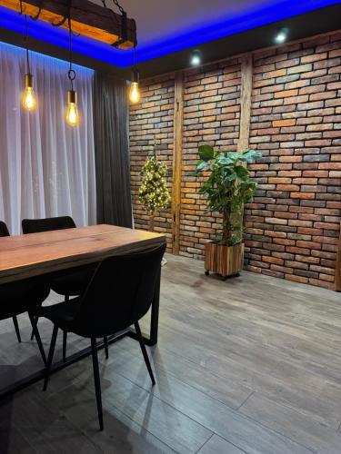 a table and chairs in a room with a brick wall at MERLIN Apartments in Zamość