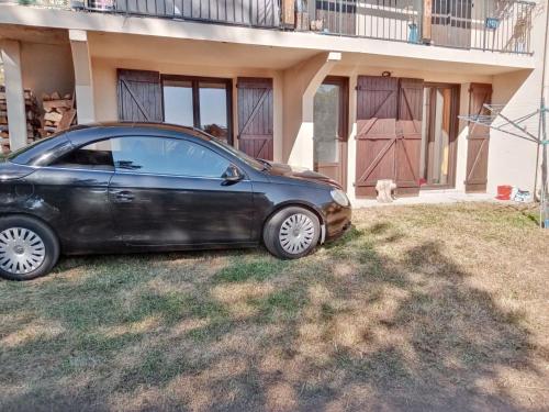 a black car parked in front of a house at Appartement charmant avec vue sur lac et montagne – 75 m² in Fontrabiouse