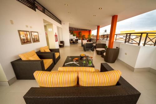 a living room with couches and a table at El Principe Hoteles in Piura