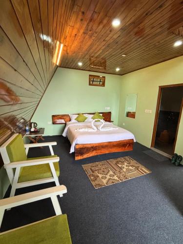 a bedroom with a large bed and a wooden ceiling at Vanam Vihara in Takdāh