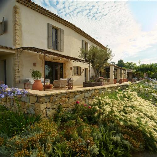 a house with a stone wall and a garden at LA BASTIDE DES CULS-ROUSSET in Marseille