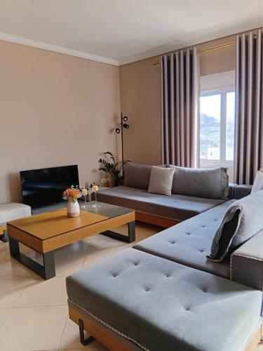 a living room with two couches and a coffee table at Amos Apartment in Sarandë