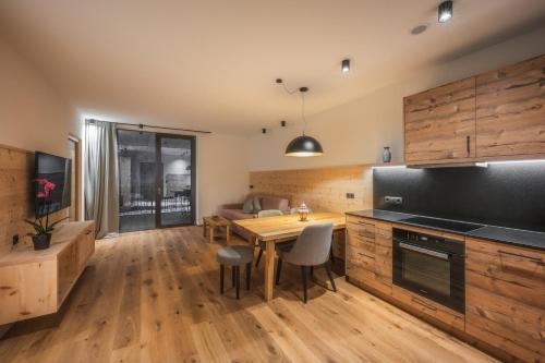 a kitchen with wooden cabinets and a wooden table at A-Lunis in Brunico
