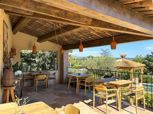 an outdoor patio with wooden tables and chairs at LA BASTIDE DES CULS-ROUSSET in Marseille