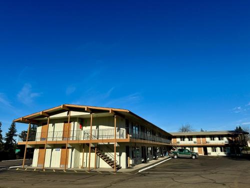 a building with a car parked in a parking lot at Snooz Inn in Wilsonville