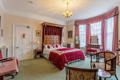 a bedroom with a bed and a desk and a piano at Banbury Cross B&B in Banbury