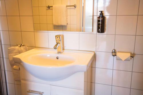 a bathroom with a white sink and a mirror at Solund Leileghetshotell in Hardbakke