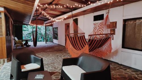 a room with two chairs and a hanging hammock at Grand Luna - Monteverde in Tilarán