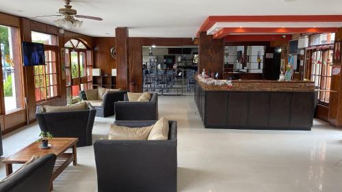 a lobby with chairs and a bar in a restaurant at San Remo Palace Hotel in Villa Gesell