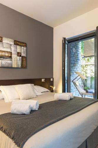 a bedroom with two beds and a large window at Il Giardino Di Lory in Vercana