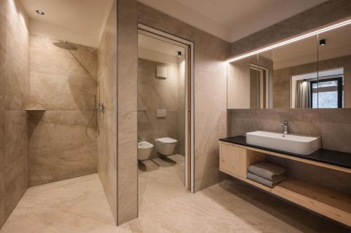 a bathroom with a sink and a shower and a toilet at A-Lunis in Brunico