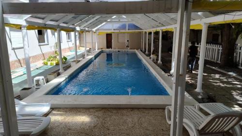 a large swimming pool with chairs and a swimming pool at San Remo Palace Hotel in Villa Gesell