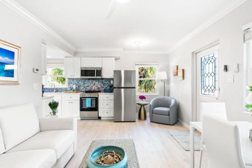 a white living room with a couch and a table at 100 Steps to beach access - 5 minute walk to the Village - Private Porch in Siesta Key