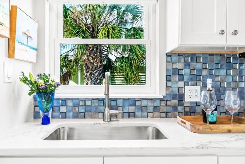a kitchen sink with a window in a kitchen at 100 Steps to beach access - 5 minute walk to the Village - Private Porch in Siesta Key