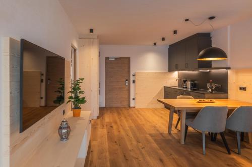 a kitchen and dining room with a table and chairs at A-Lunis in Brunico