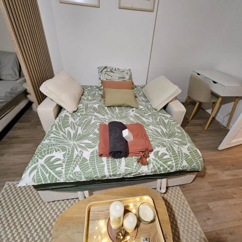- un lit dans un salon avec une table dans l'établissement Magnifique Studio rénové centre-ville 3pers wifi, à Romilly-sur-Seine