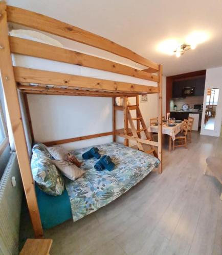 a bedroom with a bunk bed and a table at La marmotte in La Bresse