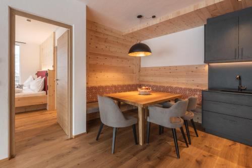 a kitchen and dining room with a wooden table and chairs at A-Lunis in Brunico