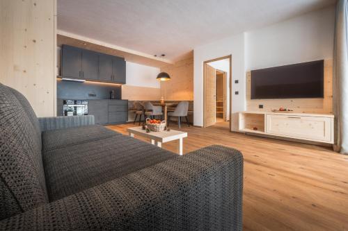 a living room with a couch and a flat screen tv at A-Lunis in Brunico