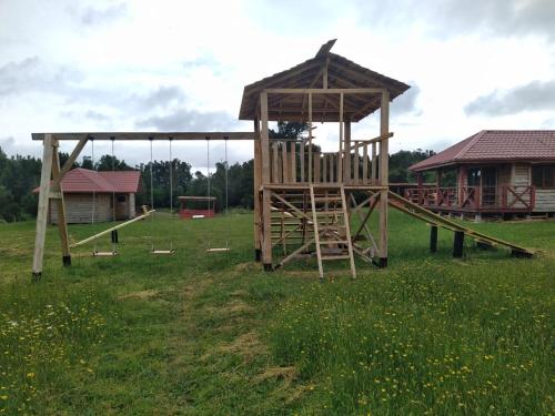 a wooden playground with a slide and a gazebo at Reipun-Ko Cabañas in Puyehue