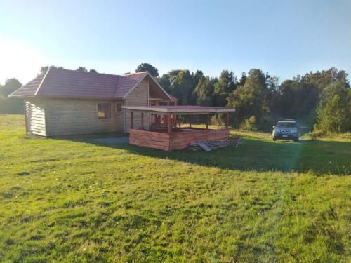 a house with a deck in a field at Reipun-Ko Cabañas in Puyehue