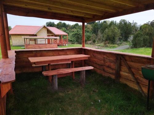 a wooden porch with a bench and a cabin at Reipun-Ko Cabañas in Puyehue