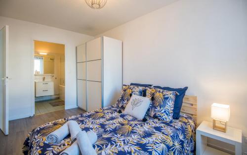 une chambre avec un lit avec des draps bleus et blancs dans l'établissement Le City, à Rodez