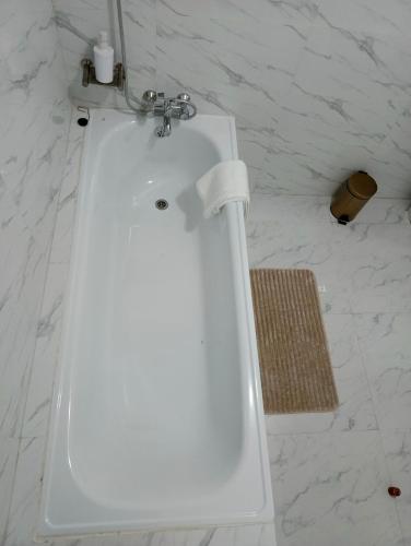 a white sink in a bathroom with white marble walls at Semuya Apartments in Ndola