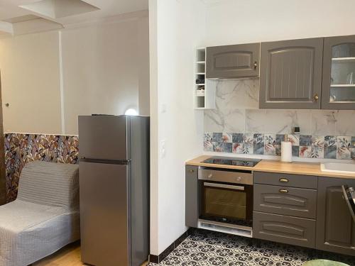 a kitchen with a stainless steel refrigerator and a bed at 2 Pièces Joinville- le- Pont in Joinville-le-Pont
