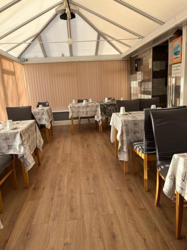 a restaurant with tables and chairs with white table cloth at Taldrwst farmhouse guest house in Dwyran