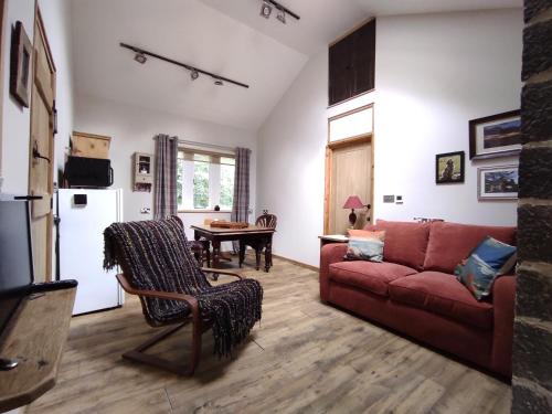 a living room with a red couch and a table at Headingley Hideaway in Headingley