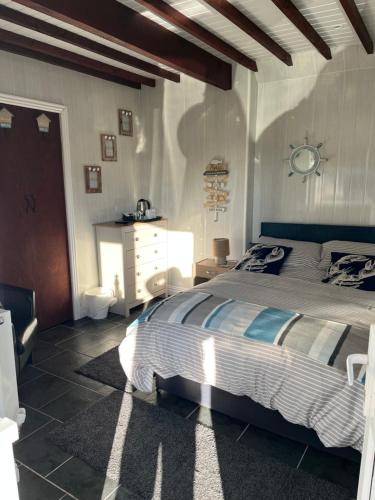 a bedroom with a bed and a white dresser in it at Taldrwst farmhouse guest house in Dwyran