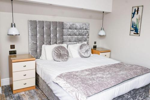 a bedroom with a large white bed with two pillows at New Wilmington Hotel in Eastbourne